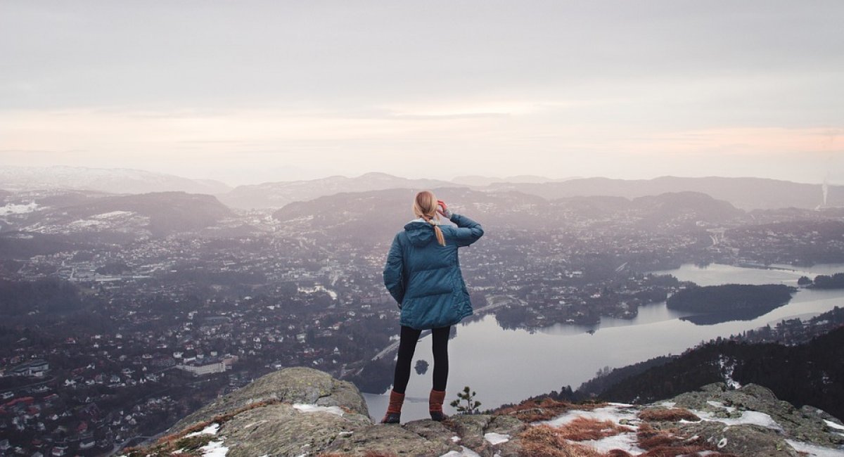 Look back! Person standing on top of a mountain looking at the view