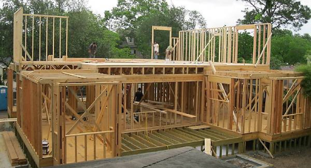 Construction workers on top of a house frame