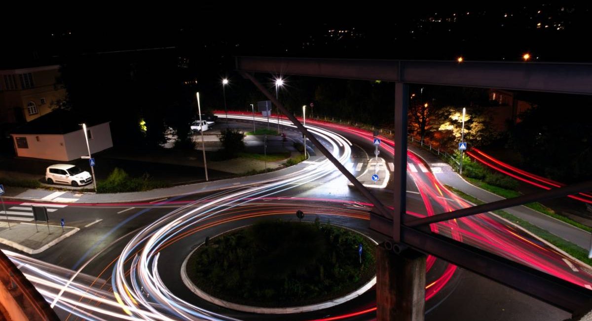 Time-lapse photo of cars going around a traffic circle at night