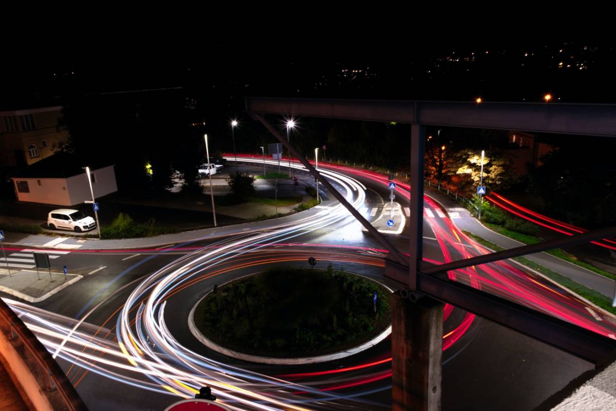 Time-lapse photo of cars going around a traffic circle at night