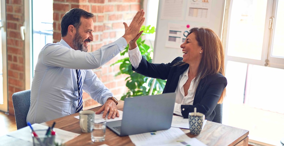 Man and woman in office giving high five