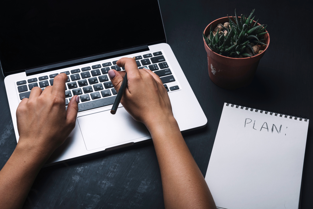 A notepad and laptop on a desk