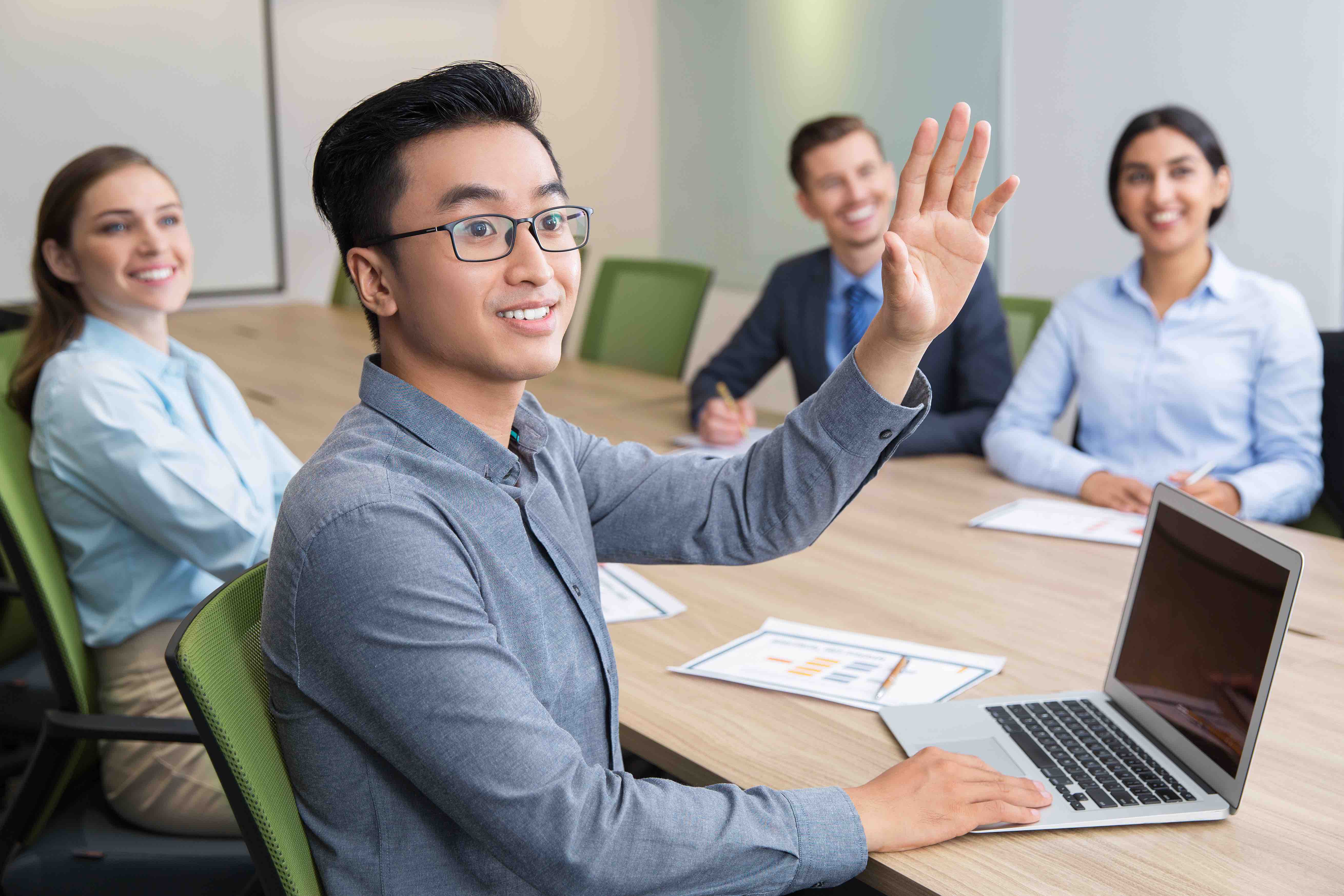 young man Asian raising hand group table class