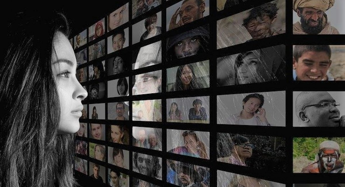 Woman looking at a mirror made up of other faces