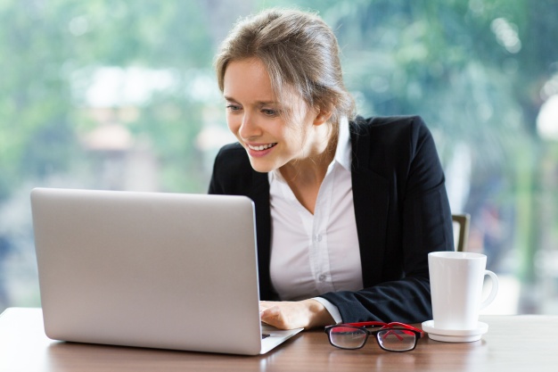 Smiling businesswoman sitting in front of a laptop