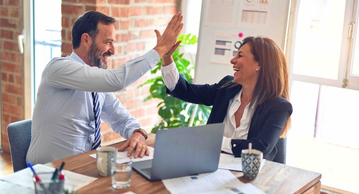 Man and woman in office giving high five