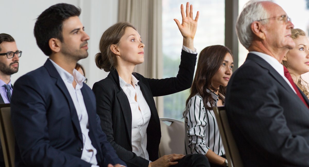 Woman raising her hand in a meeting