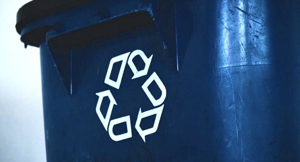 Recycling logo in white on blue trash can