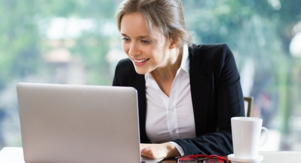 Smiling businesswoman sitting in front of a laptop